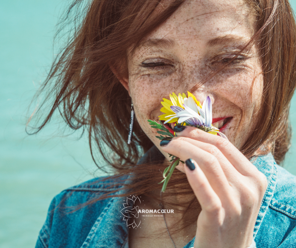 Femme souriante qui sent une fleure